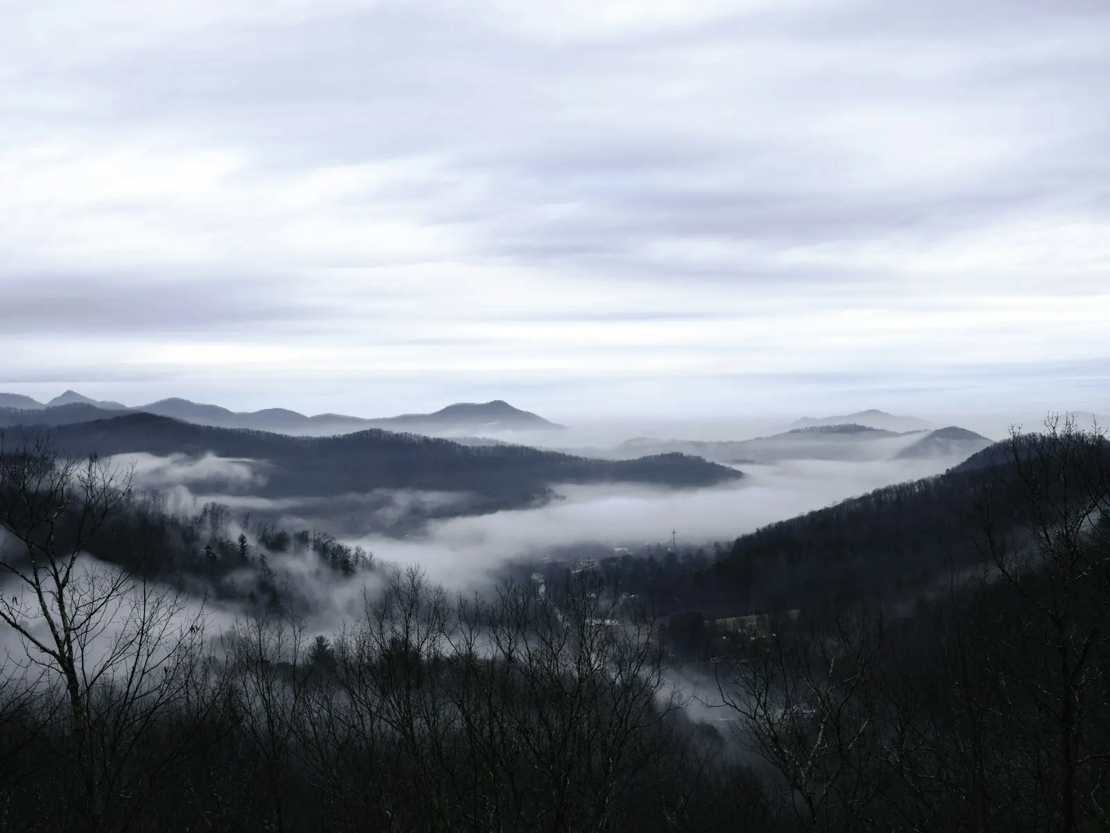 Layered hills emerging through early morning fog