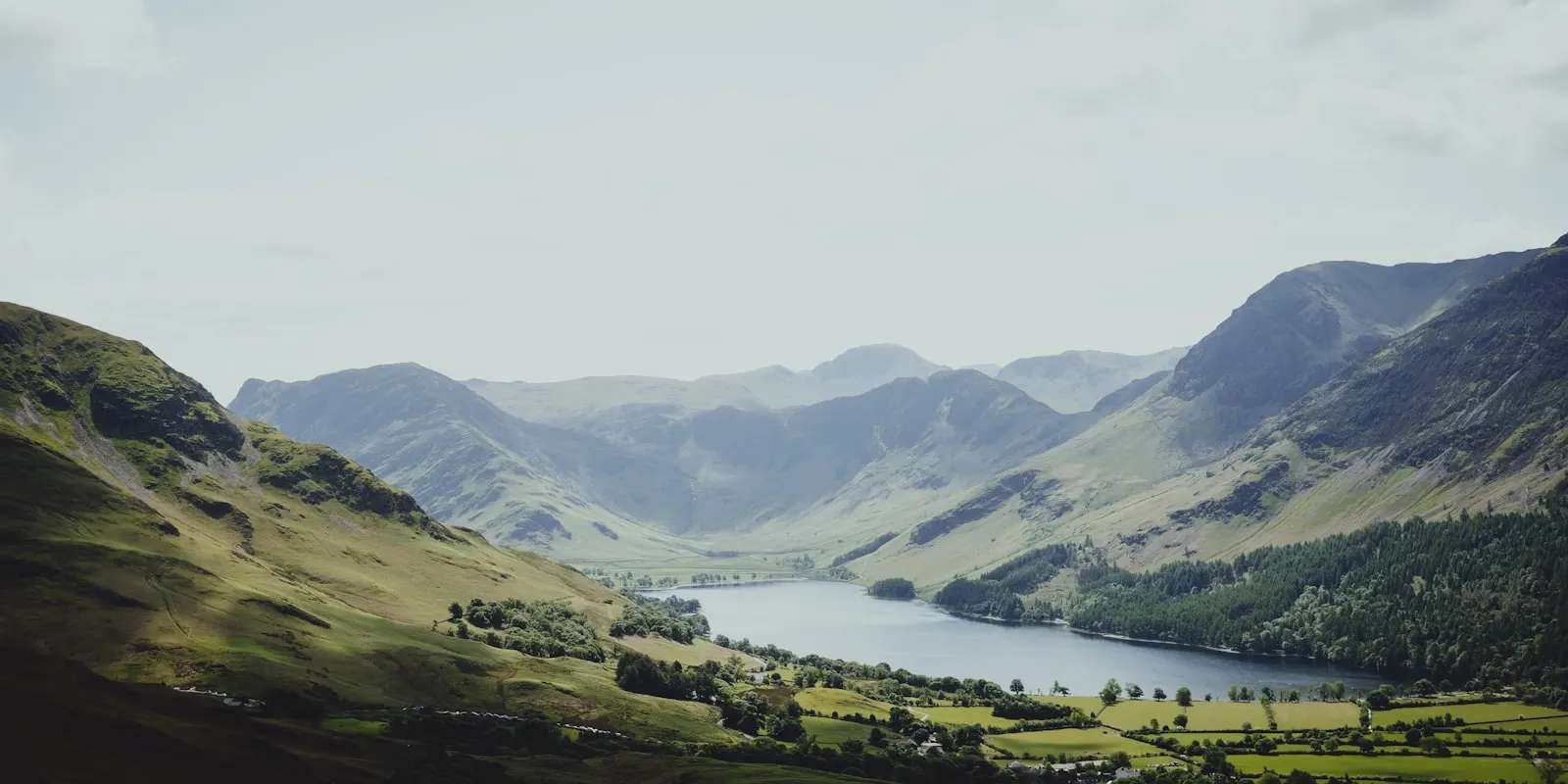 A wide view across a lake and surrounding fells